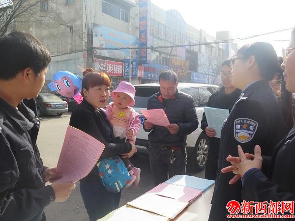 民警向群眾分發(fā)傳單宣傳居住證知識.jpg