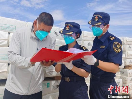 圖為蘭州海關(guān)所屬敦煌機場海關(guān)關(guān)員對出口溫石棉開展包裝查驗。王博雅 攝