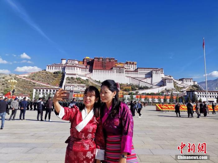資料圖:游客在拉薩布達(dá)拉宮廣場(chǎng)上拍照留念。趙延 攝 點(diǎn)擊進(jìn)入下一頁(yè)